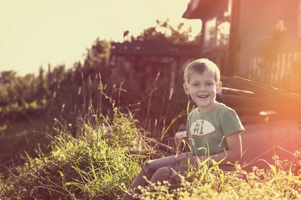 Happy cheerful funny little child sitting on grass — Stock Photo, Image