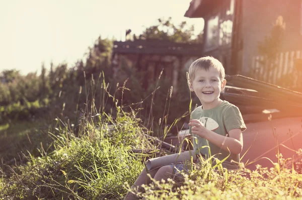 Щасливий веселий смішний маленький дитина сидить на траві — стокове фото