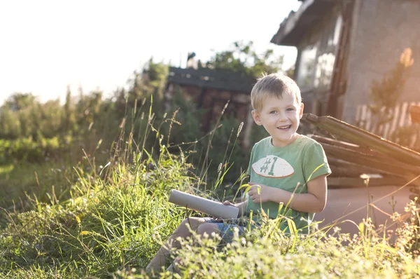 Fröhlich fröhlich lustiges kleines Kind auf Gras sitzend — Stockfoto