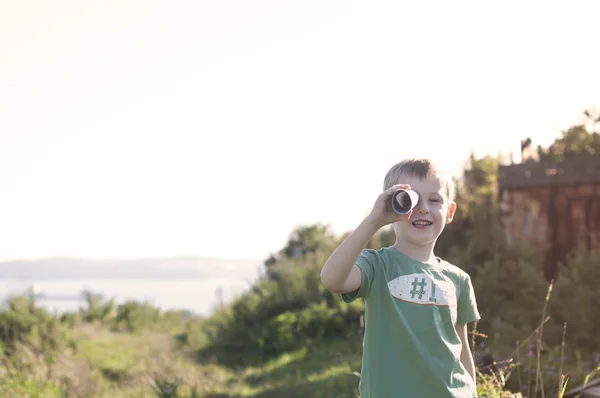 Little child playing pirate, looking at spyglass made from cardb — Stock Photo, Image