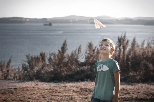 Bambino che gioca con l'aeroplano di carta — Foto Stock