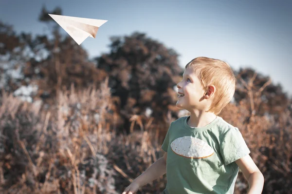 Дети играют с бумажным самолетом — стоковое фото