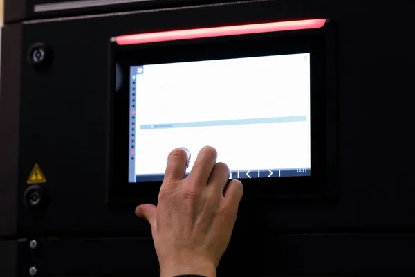 Working with a touch screen control panel of industrial equipment. Selective focus.