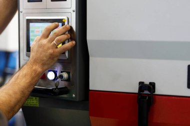 İşçi dokunmatik ekran kullanarak modern ekipmanların işleyişini kontrol ediyor. Seçici odak.