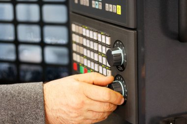 Engineer tunes parameters of CNC machine. CNC control panel closeup. Selective focus.