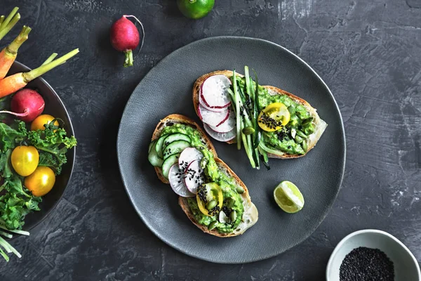 Puré Aguacate Con Tomate Pepino Rábano Sésamo Tostadas Fotos de stock