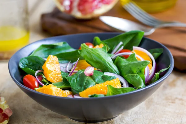 Orange with spinach and pomegranate salad — Stock Photo, Image