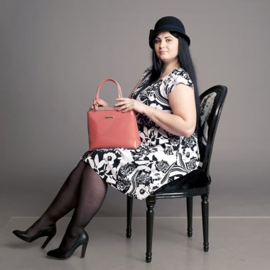 corpulent brunette in a head with a ladies' handbag