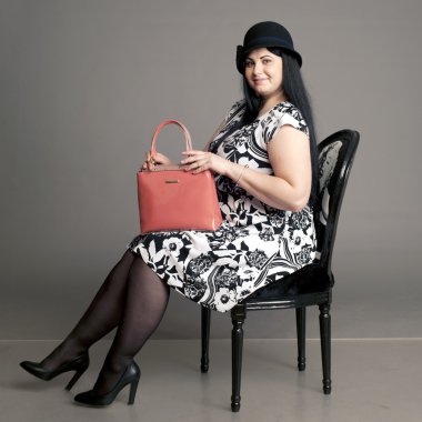 corpulent brunette in a head with a ladies' handbag