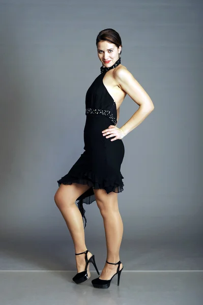 Молода красива леді танцює в чорній сукні з декольте танго — стокове фото