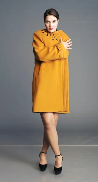 slender lady in a yellow coat