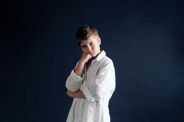 Boy the blonde, boy in a white shirt on a black background — Stock Photo, Image