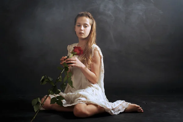 Chica con una rosa roja, chica en camisón, chica de blanco sobre fondo negro — Foto de Stock