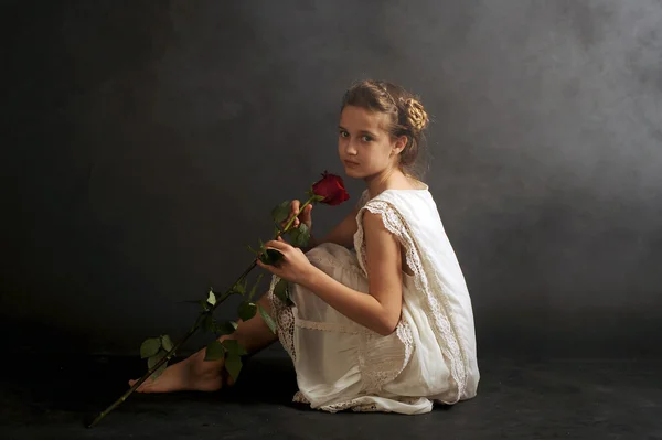 Girl with a red rose, girl in a nightgown, girl in white on a black background — Stock Photo, Image