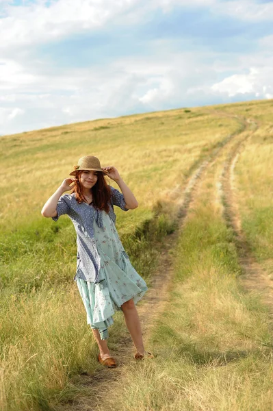 Девушка в соломенной шляпе, ветер в поле — стоковое фото