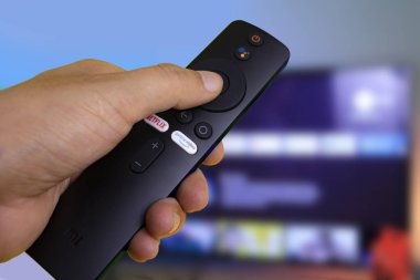 İçinde şarj aleti, uzaktan kumanda, mikro usb kablosu ve el kitapları olan android TV çubuğu..