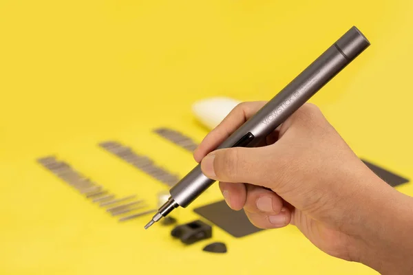 wowstick destornillador electrico de mano para trabajos de reparacion ve Industria. Herramienta sobre un fondo blanco, amarillo y azul