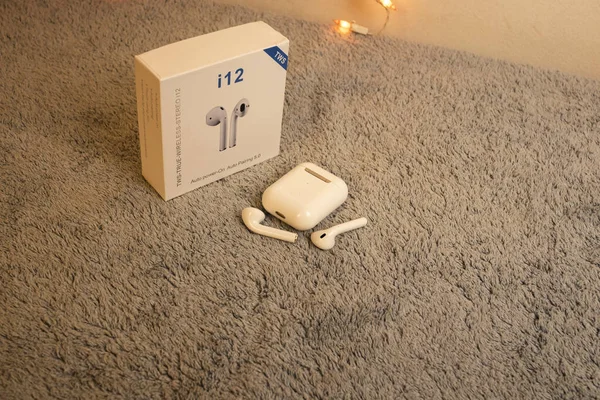 i12 TWS beyaz kulaklıklar gri pelüş üzerinde izole