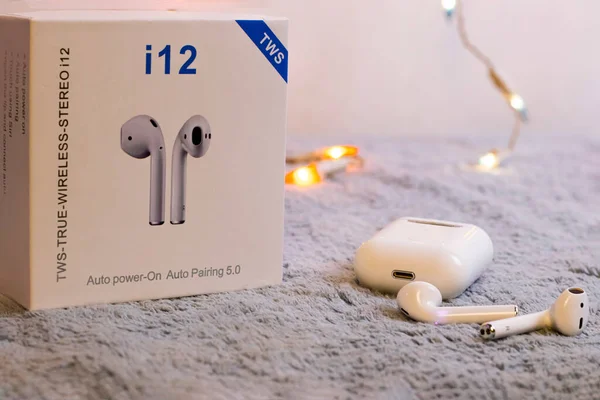 i12 TWS beyaz kulaklıklar gri pelüş üzerinde izole