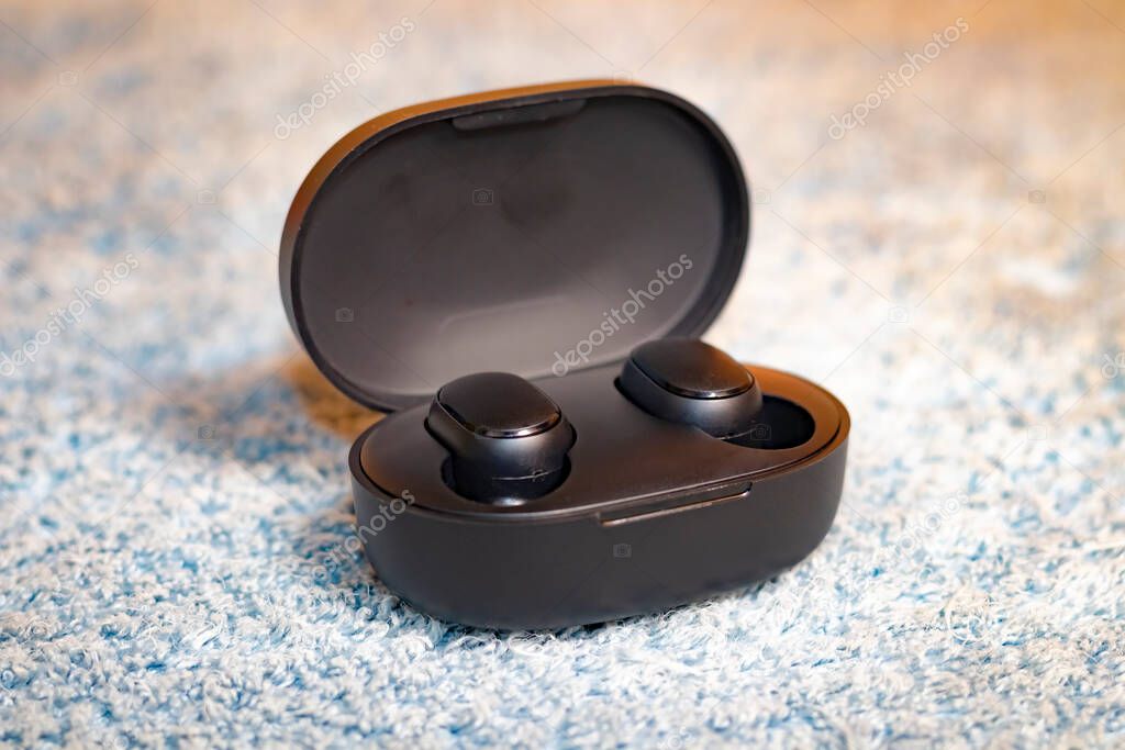 Wireless black headphones isolated on gray plush
