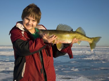 A Young Ice fisherman with a large Walleye clipart