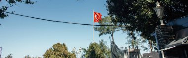 İstanbul 'da sokakta mavi gökyüzü arkaplanda kırmızı kamyonet bayrağı, afiş
