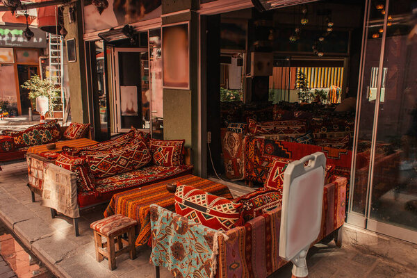 Tables and sofas with oriental ornaments in outdoors cafe on sidewalk in Istanbul, Turkey 
