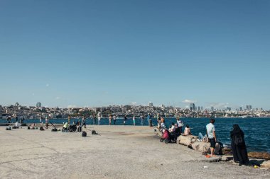 İSTANBUL, TURKEY - 12 Kasım 2020: Deniz kıyısında çubukları olan insanlar ve balıkçılar 