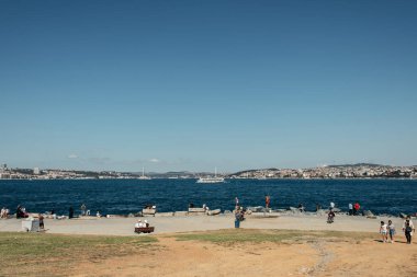 ISTANBUL, TURKEY - NOVEMBER 12, 2020: People walking on sea coast near water at daytime clipart
