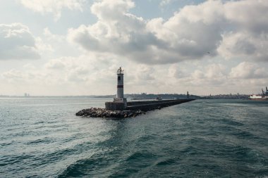 Pier and lighthouse in sea with cloudy sky at background, Istanbul, Turkey  clipart