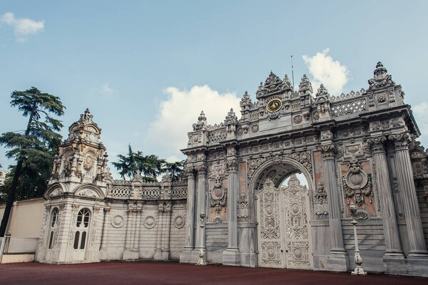 Gate of historical Dolmabahce palace and clouds in sky at background, Istanbul, Turkey 
