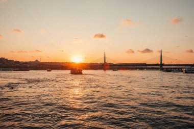 Türkiye 'nin İstanbul kentinde deniz manzarası, Altın Boynuz metro köprüsü ve günbatımı gökyüzü 