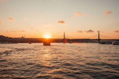 Türkiye 'nin İstanbul kentinde deniz manzarası, Altın Boynuz metro köprüsü ve günbatımı gökyüzü 