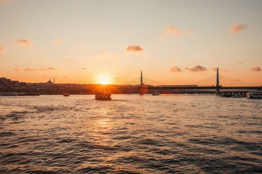 Scenic view of boast in sea, Golden horn metro bridge and sunset sky in Istanbul, Turkey  clipart
