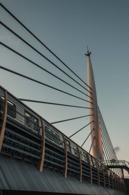 Altın Boynuz metro köprüsündeki trenin alçak açılı görüntüsü, arka planda günbatımı gökyüzü, İstanbul, Türkiye 