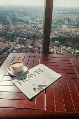 travel newspaper and cup of coffee near window with aerial view of Istanbul, Turkey clipart