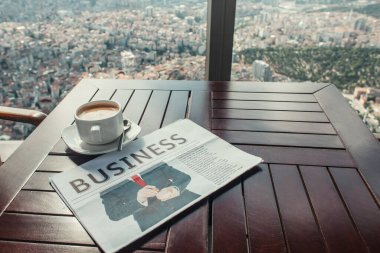 iş gazetesi ve kahve fincanı pencerenin yanındaki İstanbul manzaralı kafede.