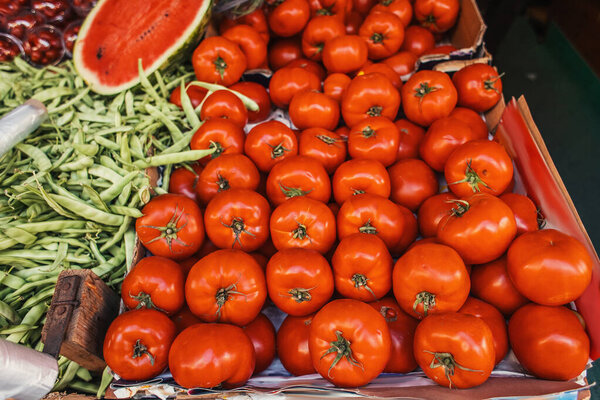 High angle view of ripe tomatoes and beans on stall of outdoors market