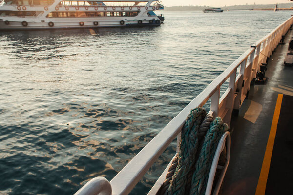 Rope on ship railing with boat on water on blurred background, Istanbul, Turkey 