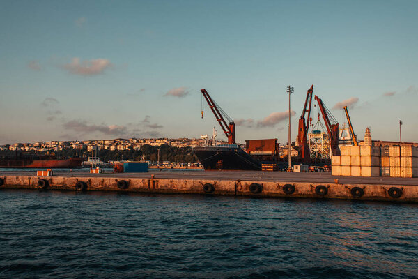 Тяжелая техника в морском порту Стамбула на закате, Турция 