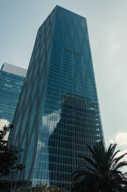 skyscraper with glass facade against blue sky in Istanbul, Turkey clipart