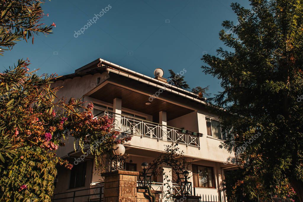 Two-storied villa near green trees