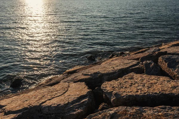 Piedras con luz solar en la costa del mar - foto de stock