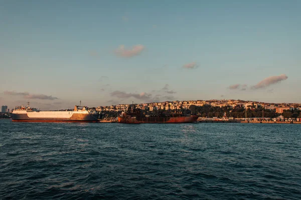 Barcos cerca del paseo marítimo y la ciudad de Estambul al atardecer, Turquía - foto de stock