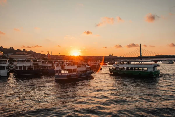 Barcos en el mar con sol al atardecer y puente de metro cuerno de oro en el fondo, Estambul, Turquía - foto de stock