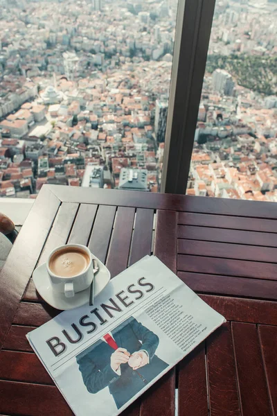 Taza de café y periódico de negocios en la mesa en la cafetería con vista aérea de Estambul, Turquía - foto de stock