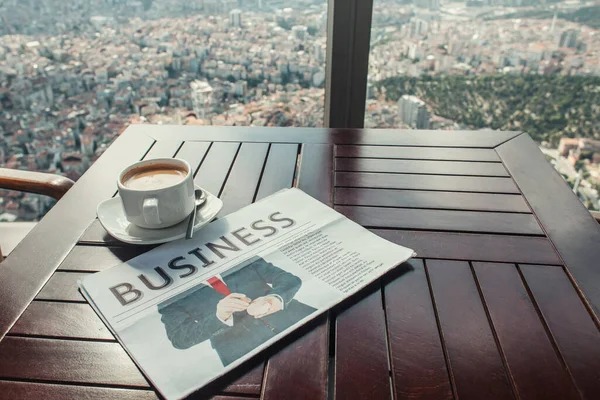 Business newspaper and coffee cup in cafe near window with aerial view of Istanbul — Stock Photo