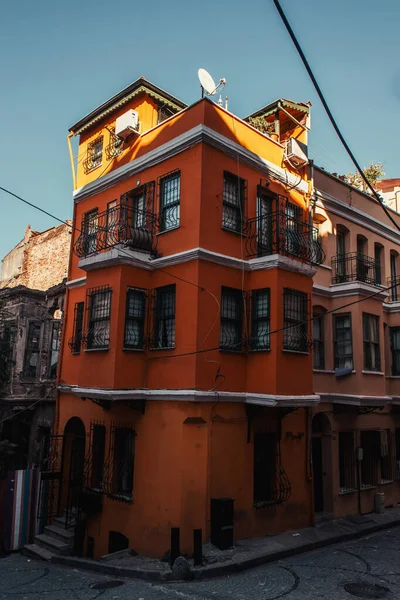Rotes, authentisches Gebäude mit eingezäunten Fenstern und Balkonen im Viertel Balat, Istanbul, Türkei — Stockfoto