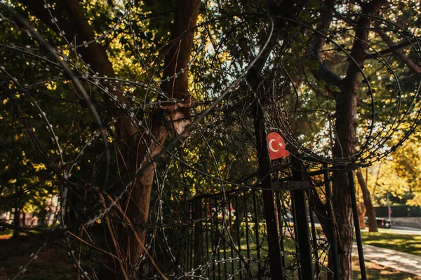 Cerca de alambre bardeado y bandera turca en el parque de Estambul, Turquía - foto de stock