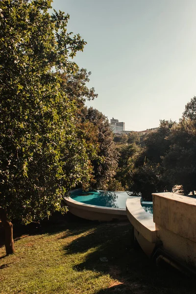 Alto, árvores verdes e artificial, lagoa em cascata no parque — Fotografia de Stock